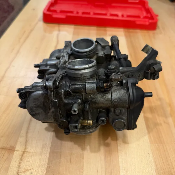 Three-quarter view showing the throttle linkage between the two carbs and the cable bracket.