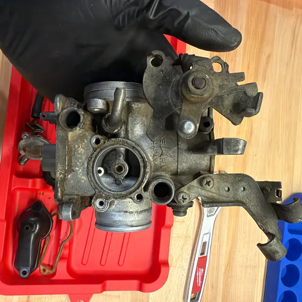 Primary carb separated from the assembly. Throttle linkage arm still attached.