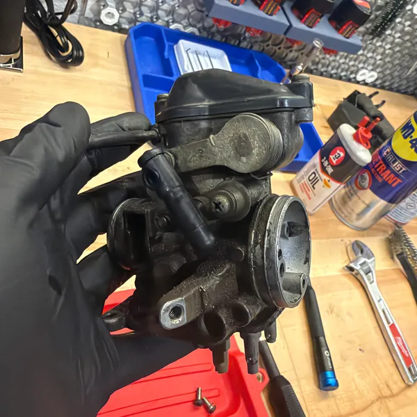 Primary carb with the top cover and the accelerator pump cover in place, before removal.