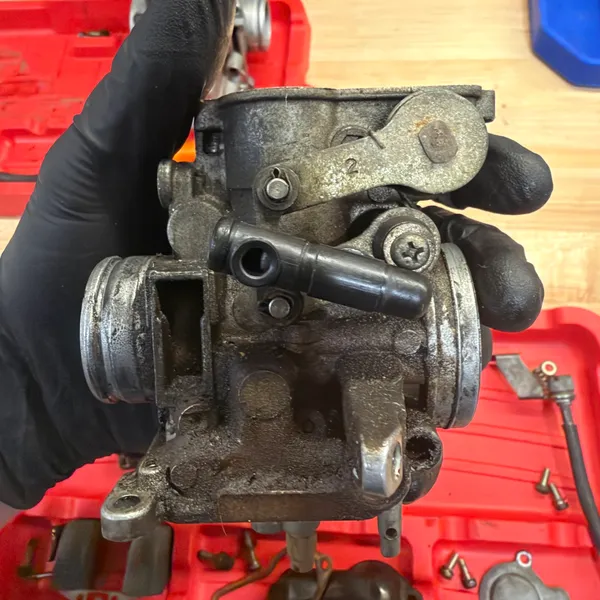 Secondary body with the fuel inlet elbow. The fitting on the side is where the crossover tube seats.