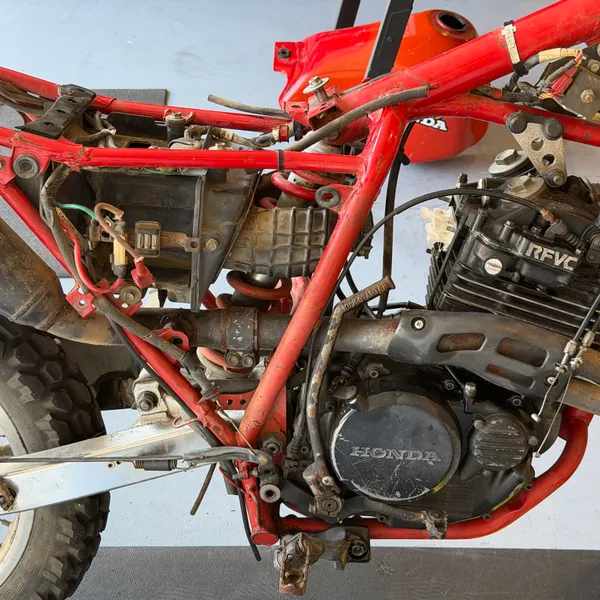 Left side, tank off, carbs already out. The intake stub on the head is exposed.