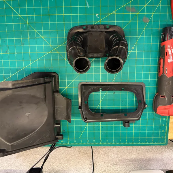 Airbox out and apart: outer cover (left), filter frame (center), and the twin boots that clamp onto the carburetors (top). Zep degreaser and a Milwaukee ratchet for scale.