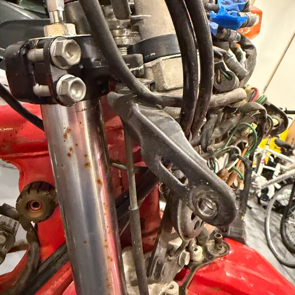 Closer on the left fork tube and the headlight stay bolt. Fork tube has pitting above the seal.