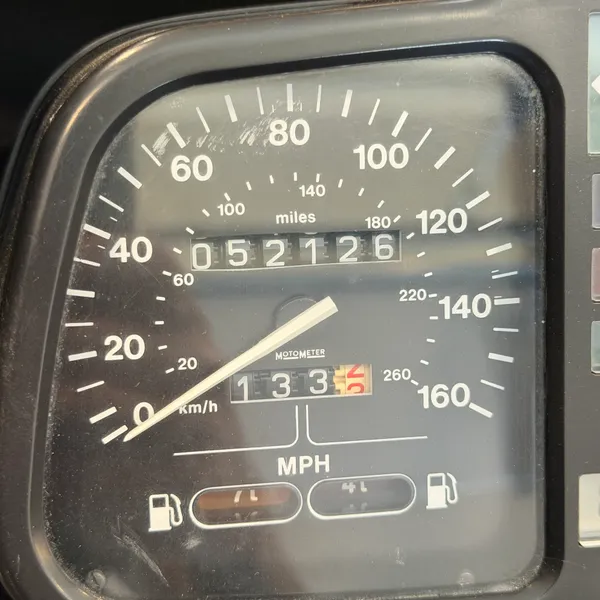 Odometer reads 5,212 miles. Whether that's the first or second trip around is anyone's guess. Speedo face is clean under the dust.