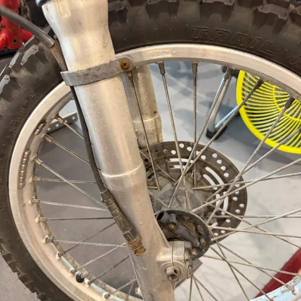 Front wheel and brake: a single disc with the caliper on the left fork leg. Rotor is scored but usable.