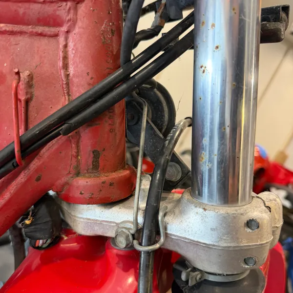 Lower triple clamp, right side, with the cables routed down the fork leg. Note the order they stack in.