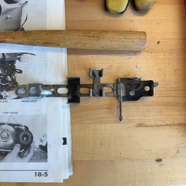 Straightened and wire-brushed, next to manual page 18-5 (Switches/Horn/Lights). A wooden mallet does less damage than a steel one.