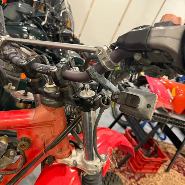 Front end from the left with the headlight off. Signal, stay, bars, and the brake master cylinder.