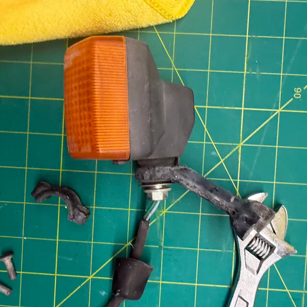 Left signal off and on the mat. Lens, body, the rubber stalk with its wire, and the mounting hardware.