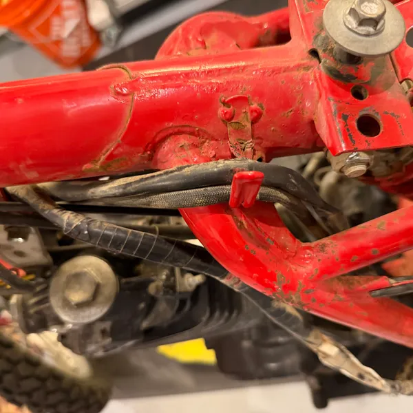 Cable ties and routing along the backbone near the top shock mount. The harness runs under the frame gusset here.
