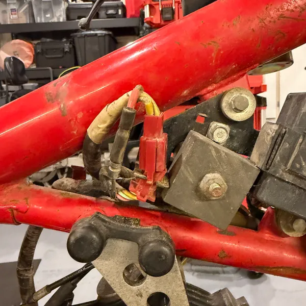 Ignition coil on its bracket on the frame downtube, plug wire exiting downward.